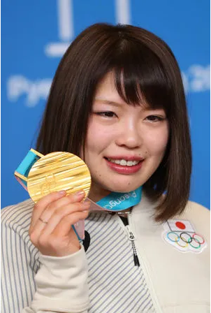 金メダルをもつ佐藤綾乃